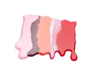 Colorful nail polishes spilled on white background