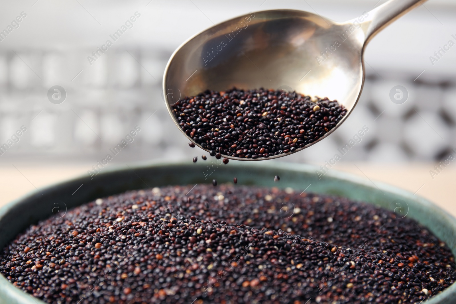 Photo of Spoon and bowl with black quinoa, closeup