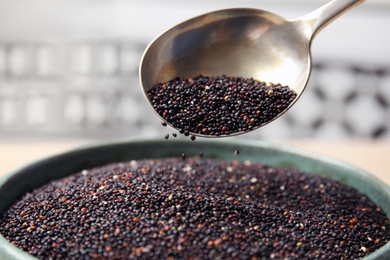 Spoon and bowl with black quinoa, closeup