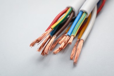 Photo of Cables with stripped wires on light background, closeup