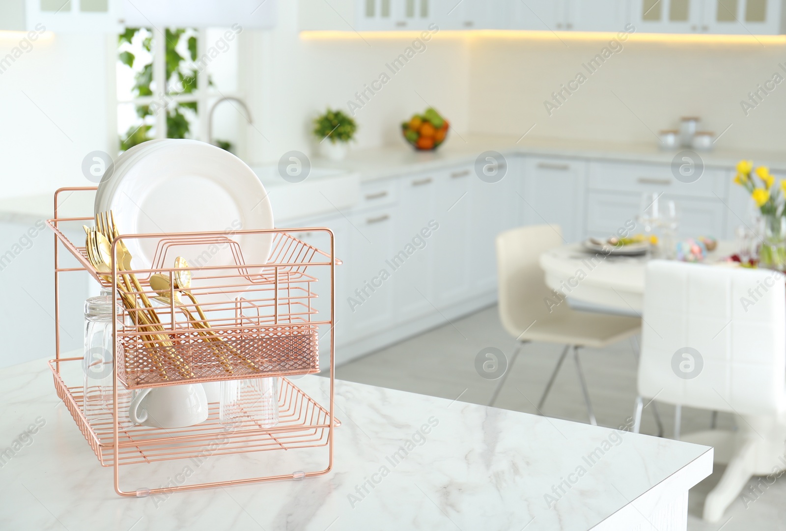 Photo of Clean dishes on drying rack in modern kitchen interior, space for text