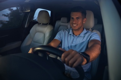 Photo of Handsome man driving his modern car, view from outside