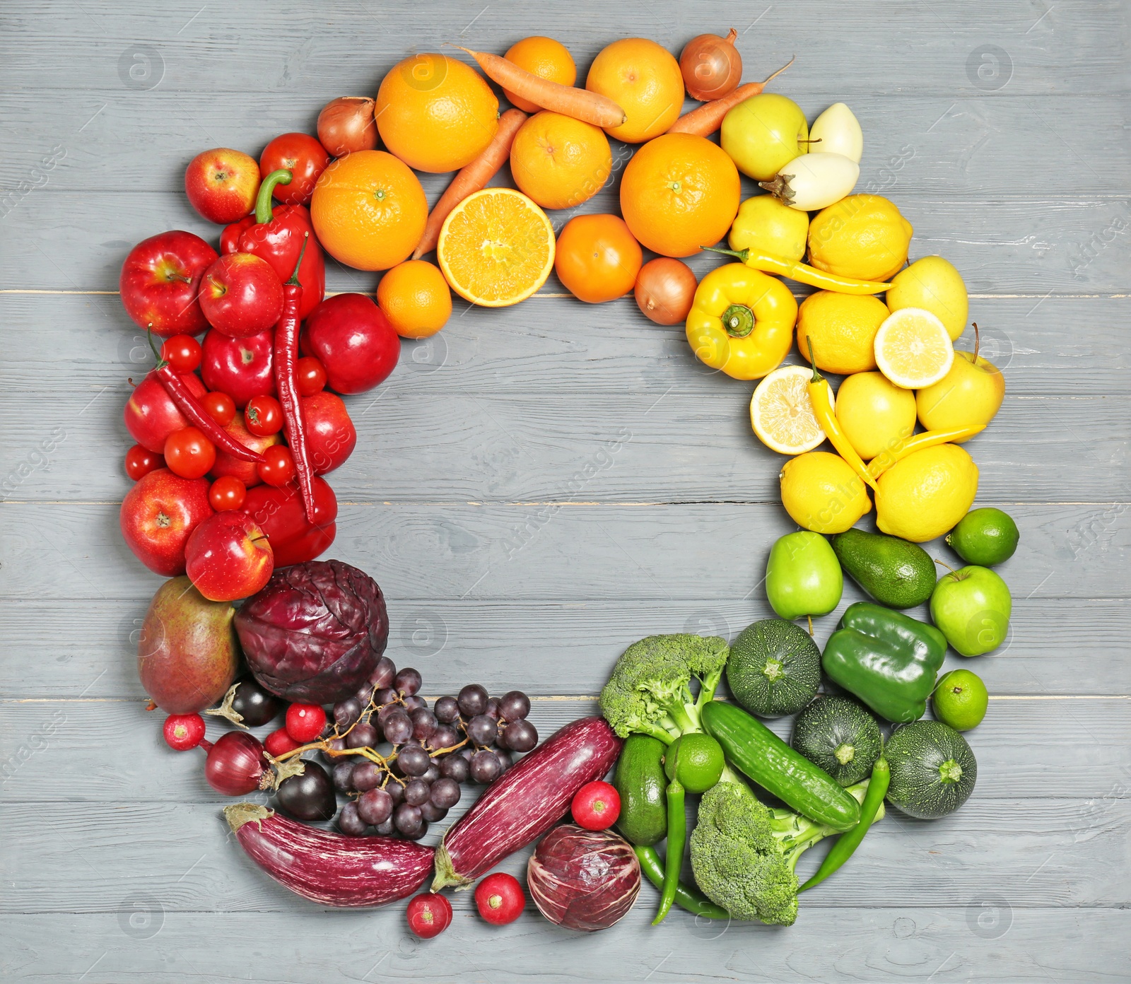 Photo of Rainbow frame made of fresh fruits and vegetables on wooden background