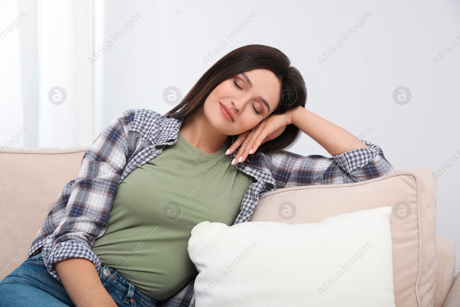 Photo of Young woman relaxing on couch at home