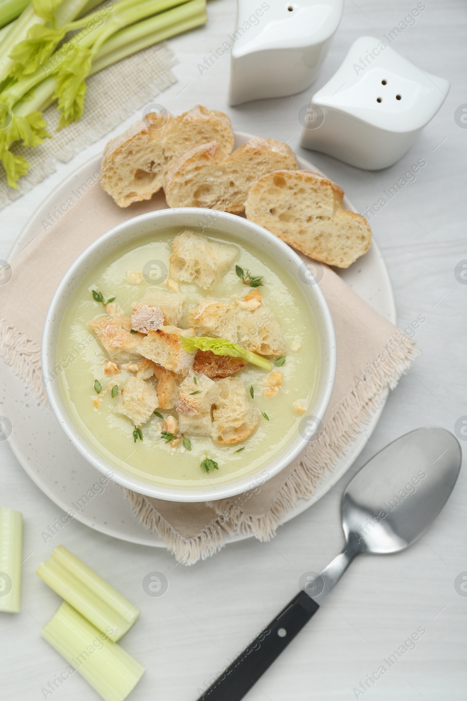 Photo of Delicious celery soup served on white wooden table, flat lay