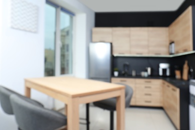 Blurred view of cozy modern kitchen interior with new furniture and appliances