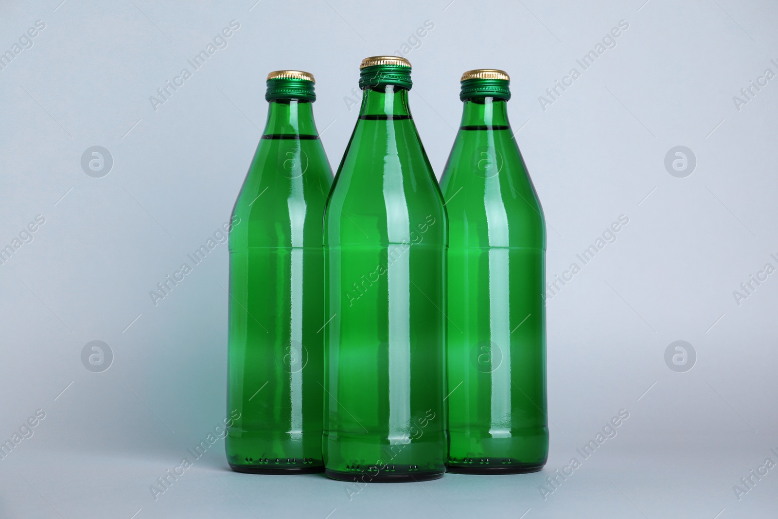 Photo of Glass bottles with water on white background