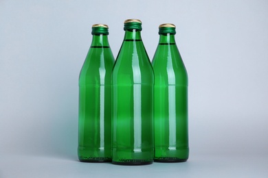Glass bottles with water on white background