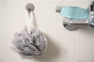 Photo of Grey shower puff and bottle of body wash gel in bathroom