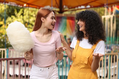 Photo of Happy friends with cotton candy spending time together at funfair