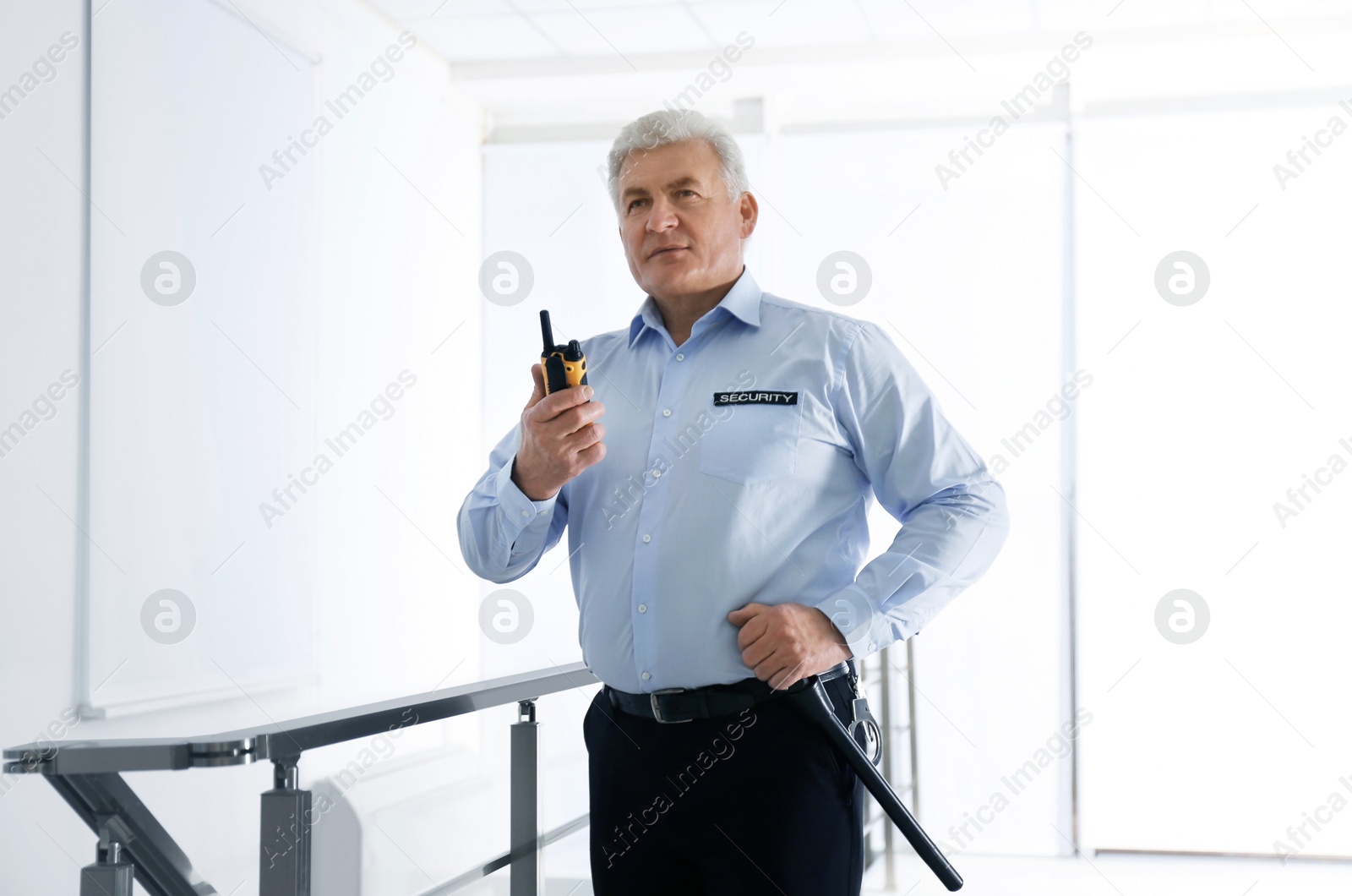 Photo of Professional security guard with portable radio set in office