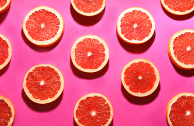 Photo of Flat lay composition with tasty ripe grapefruit slices on magenta background