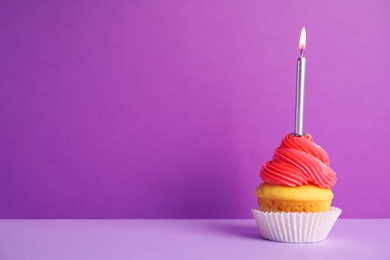 Birthday cupcake with candle on violet background, space for text