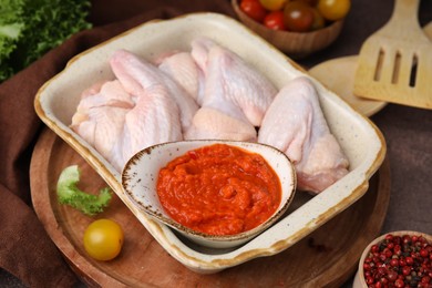 Fresh marinade and raw chicken on table, closeup