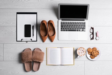 Photo of Flat lay composition with business supplies and home accessories on white wooden floor. Concept of balance between work and life