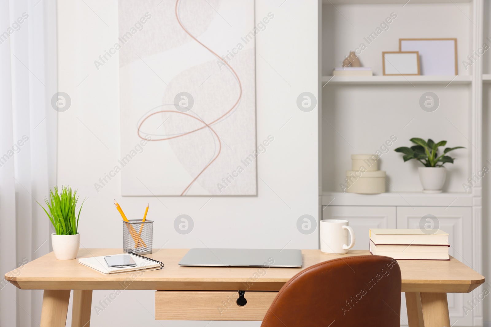 Photo of Home office. Stylish workplace with laptop and stationery on wooden desk indoors