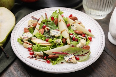 Photo of Delicious pear salad with sauce on wooden table, closeup