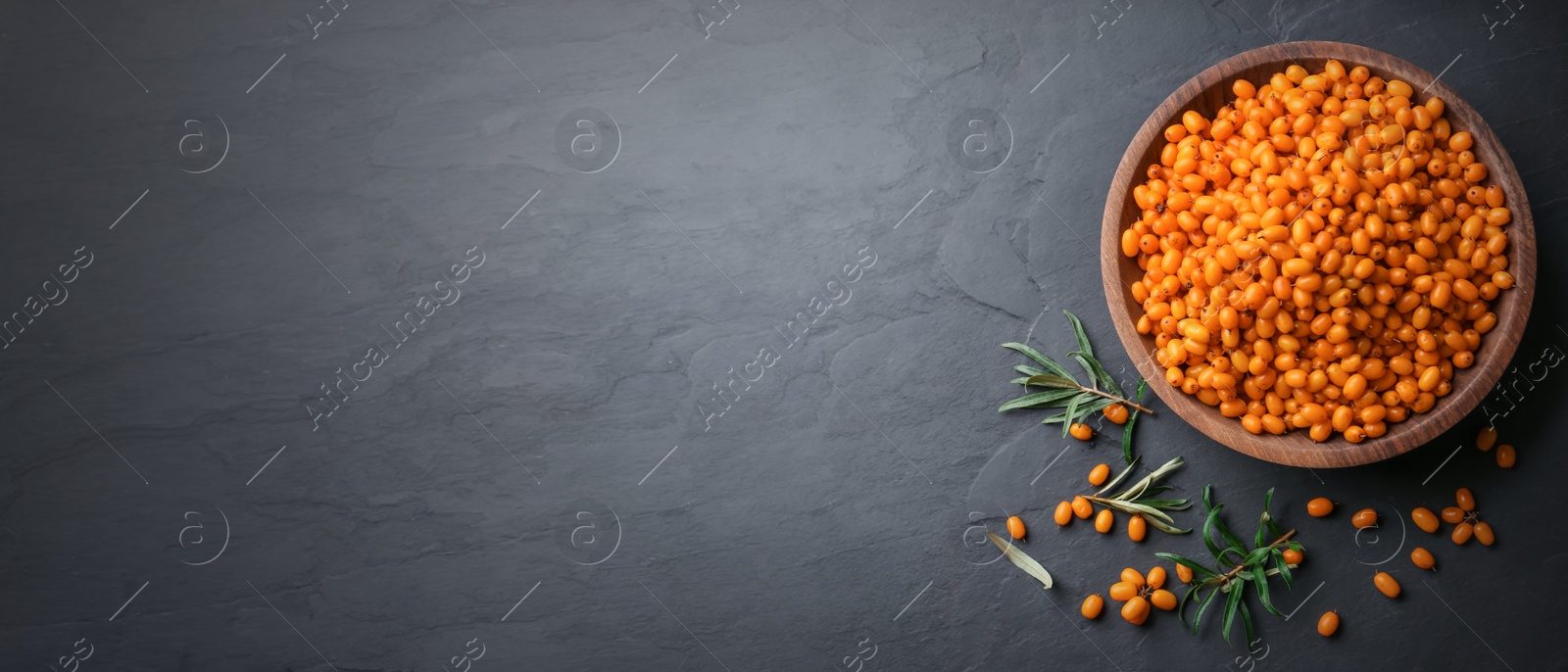 Image of Top view of fresh ripe sea buckthorn on black table, space for text. Banner design