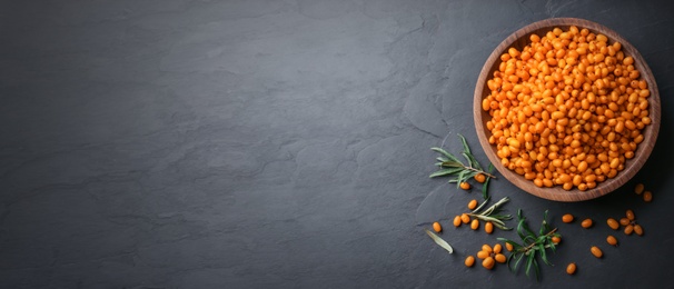 Top view of fresh ripe sea buckthorn on black table, space for text. Banner design