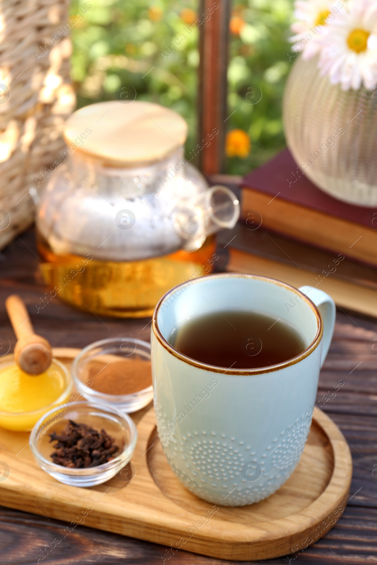 Photo of Tray with delicious tea and ingredients on wooden table