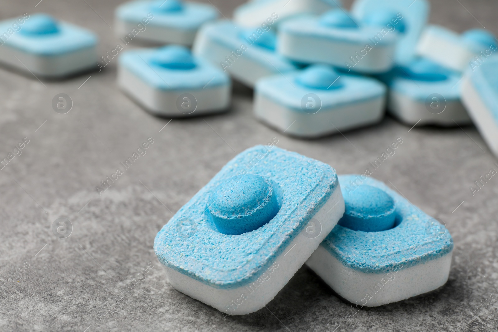 Photo of Water softener tablets on grey table, closeup. Space for text