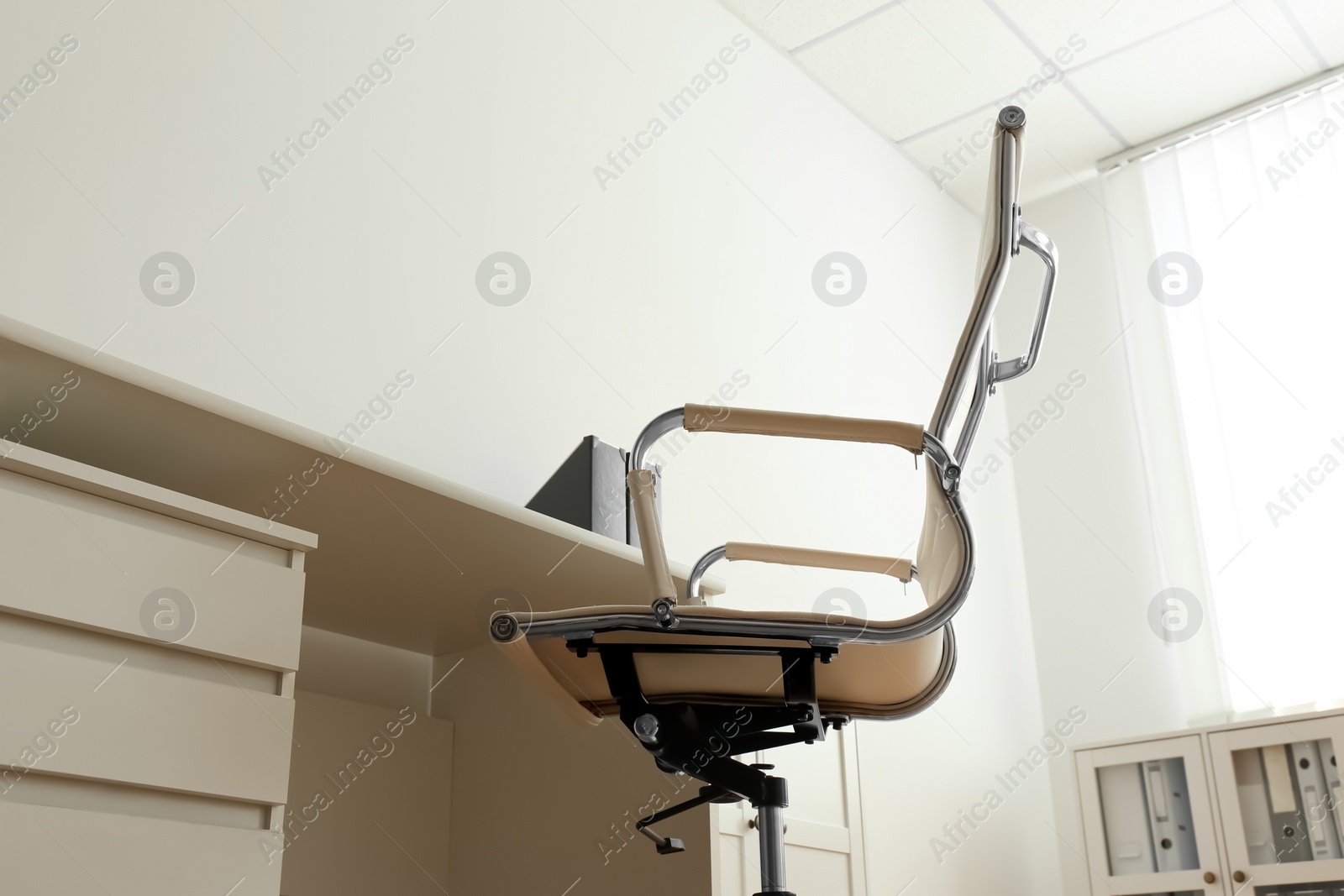 Photo of Stylish workplace interior with modern office chair and desk