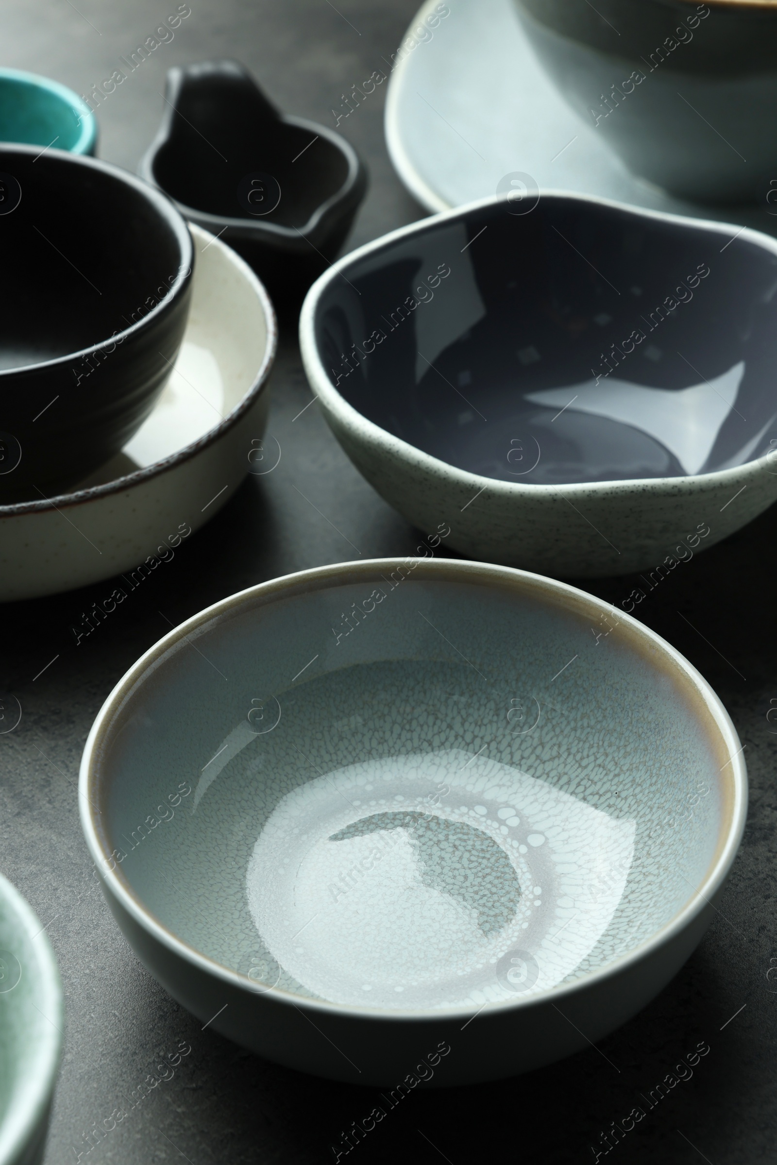 Photo of Set of stylish empty bowls on grey table