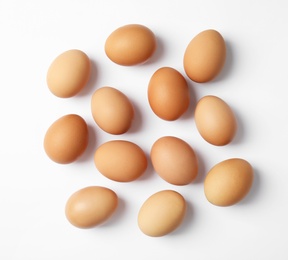 Photo of Raw chicken eggs on white background, top view