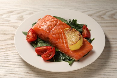 Photo of Tasty grilled salmon with tomatoes, lemon and basil on white wooden table, closeup