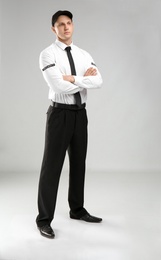 Male security guard in uniform on color background