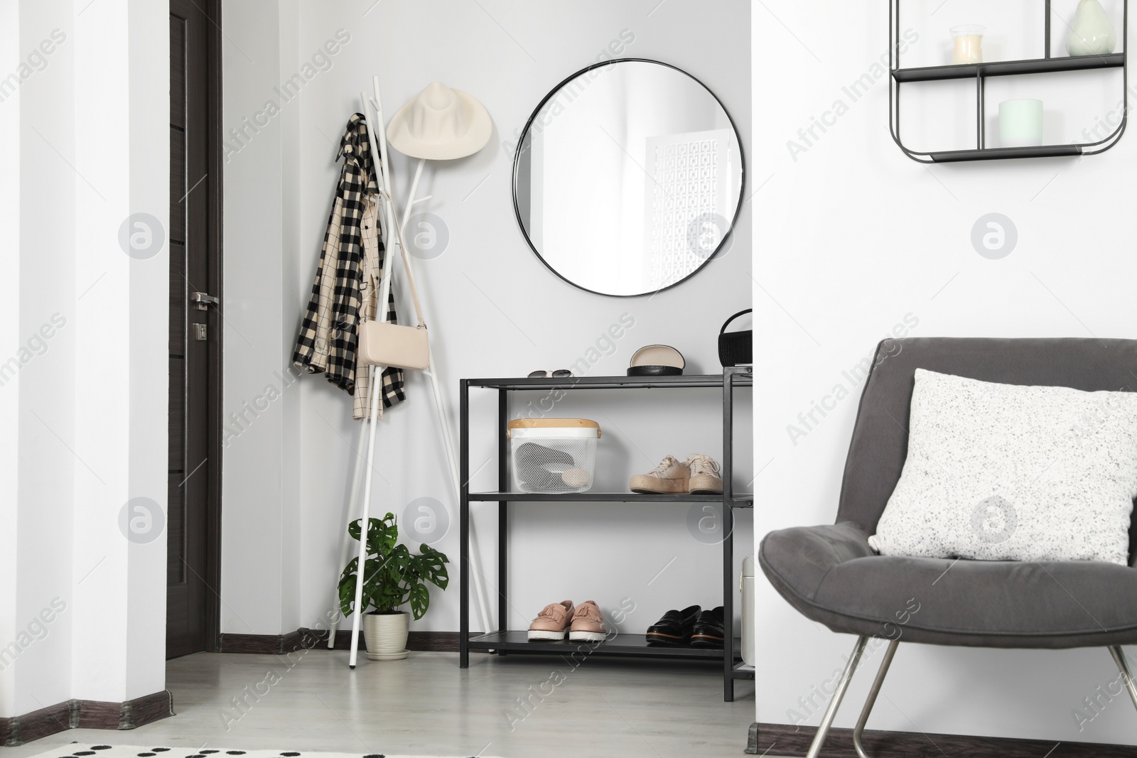 Photo of Hallway interior with stylish furniture and round mirror on light wall