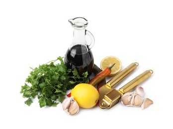 Photo of Different fresh ingredients for marinade and garlic press on white background