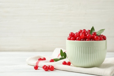 Tasty ripe cranberries on white table. Space for text