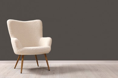 Photo of Stylish armchair near grey wall indoors, space for text