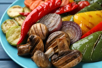 Photo of Delicious grilled vegetables on blue plate, closeup