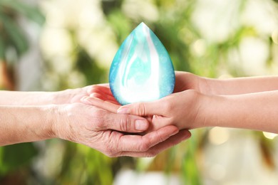 Young and elderly women image of water drop on blurred green background, closeup