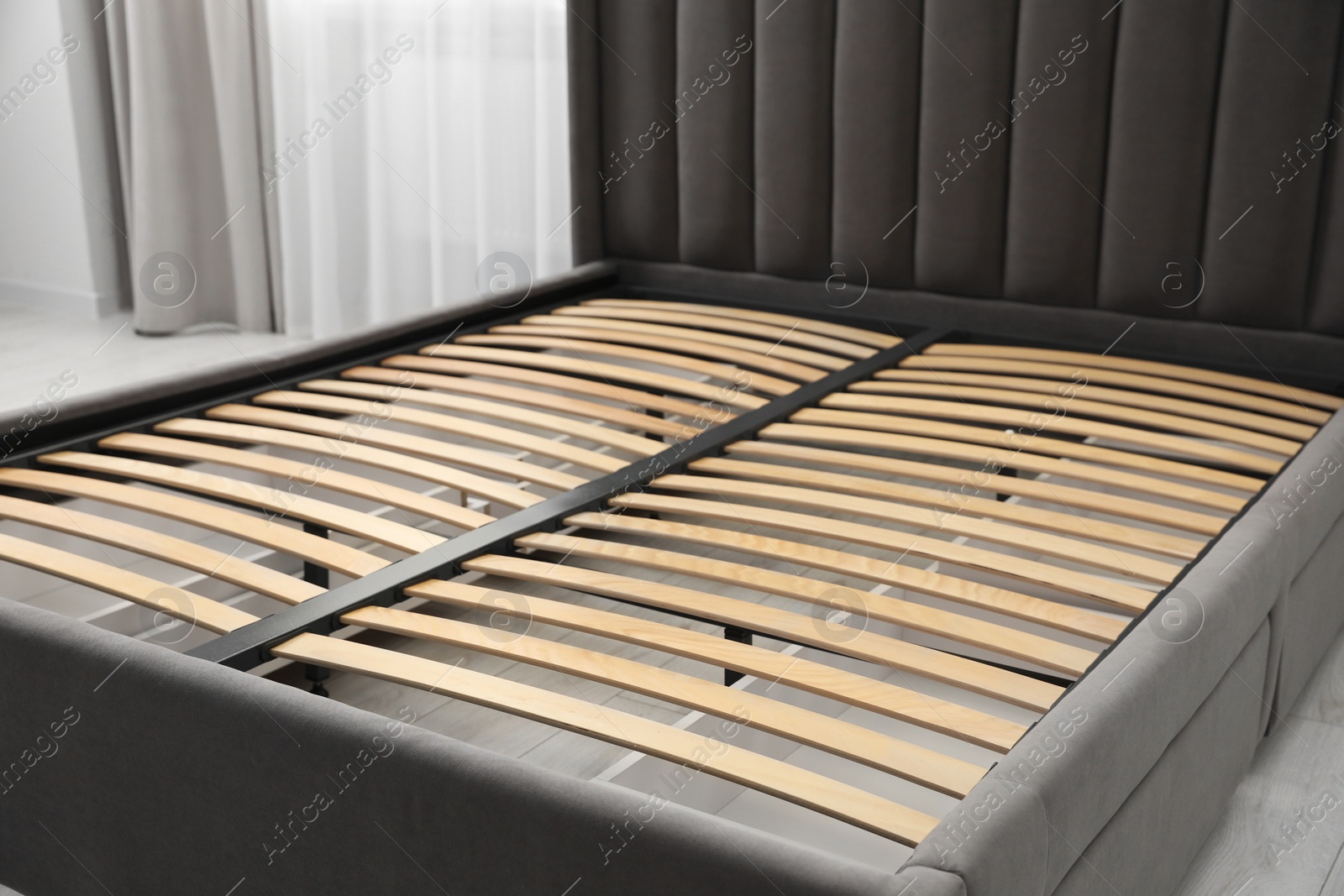 Photo of Modern bed with storage space for bedding under slatted base in room, closeup