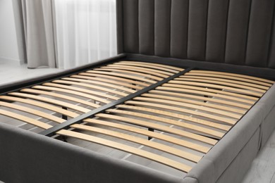 Photo of Modern bed with storage space for bedding under slatted base in room, closeup