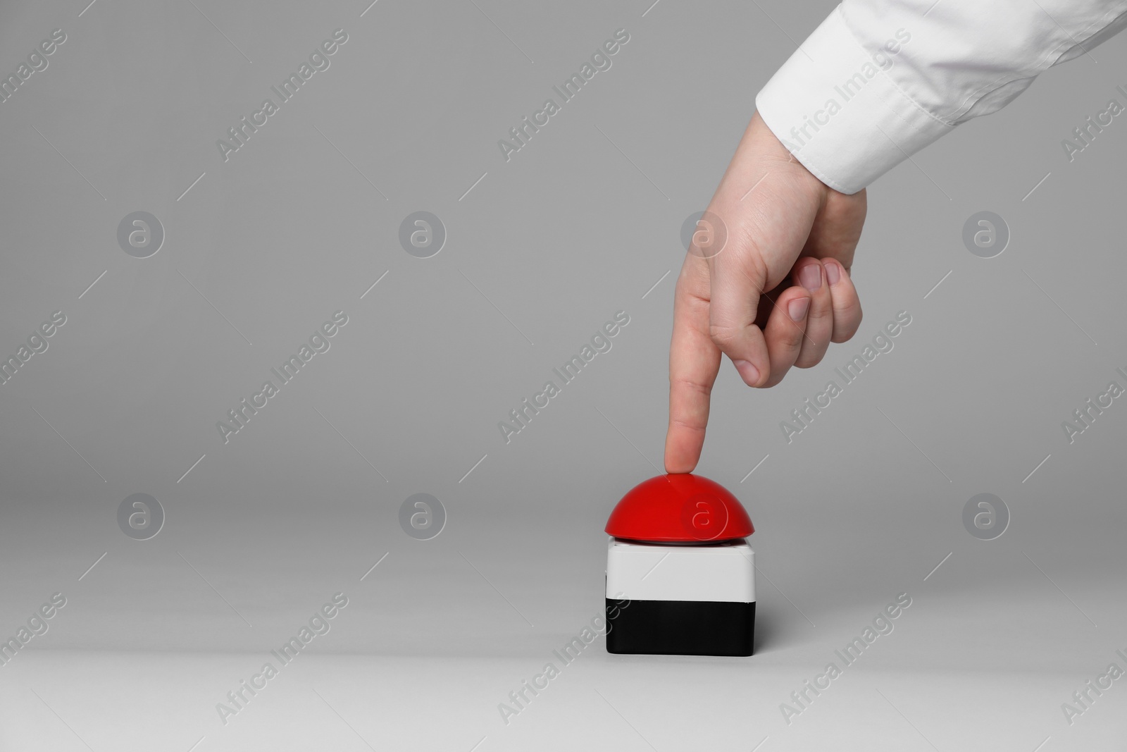 Photo of Man pressing red button of nuclear weapon on light gray background, closeup with space for text. War concept