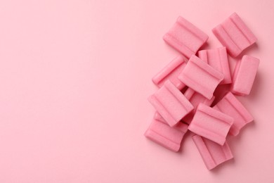 Photo of Tasty chewing gums on pink background, flat lay. Space for text