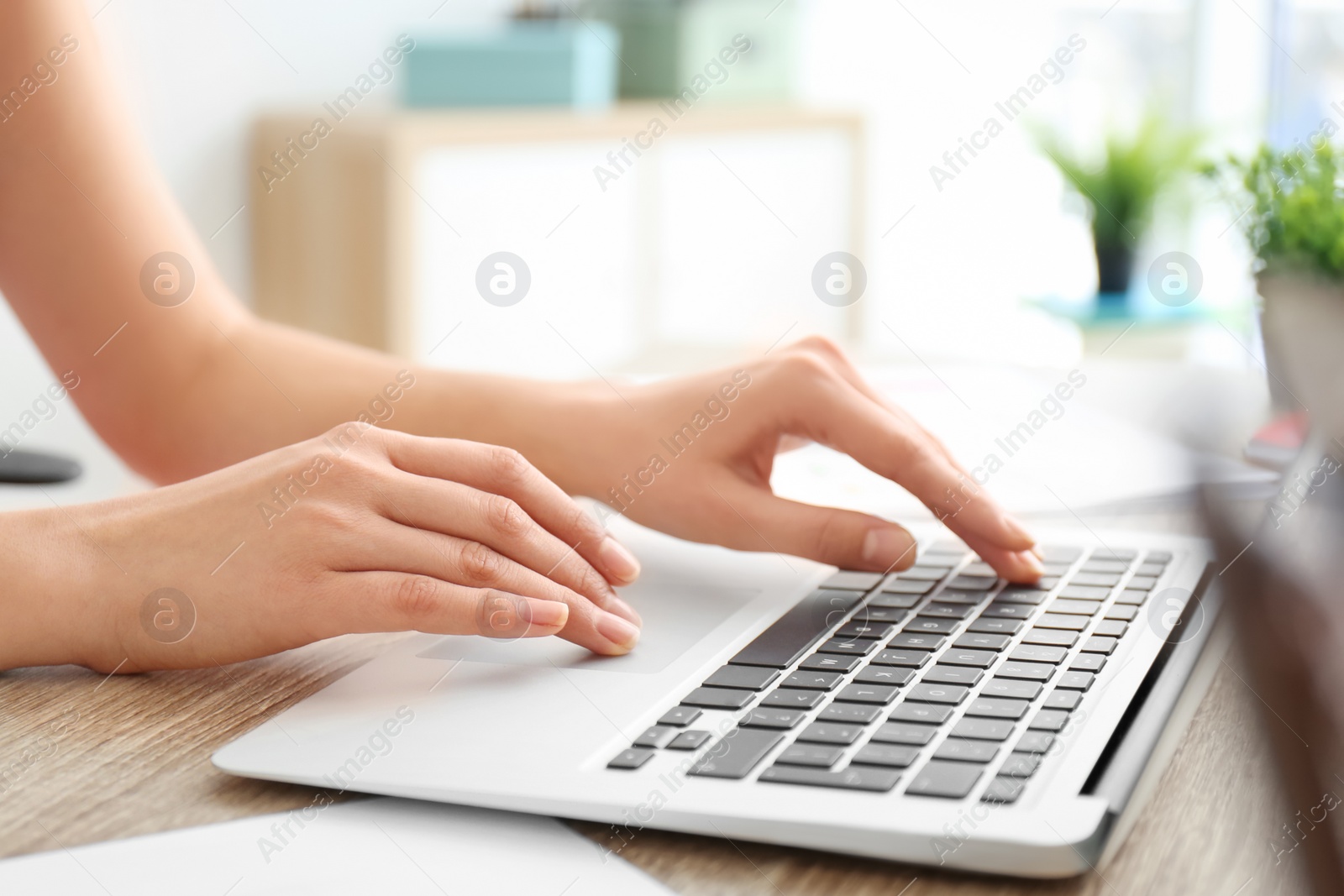 Photo of Young woman using laptop indoors, closeup