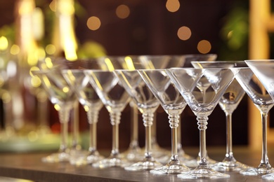 Photo of Empty martini glasses on table against blurred background