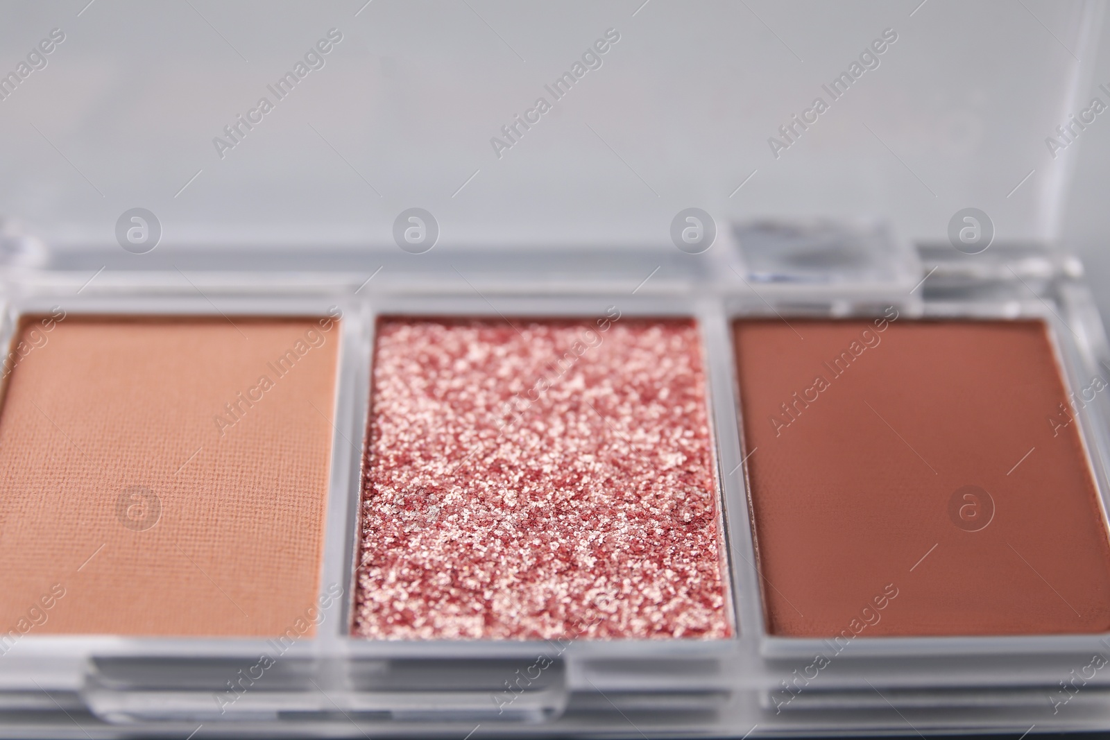 Photo of Beautiful eyeshadow palette on light background, closeup. Professional cosmetic product