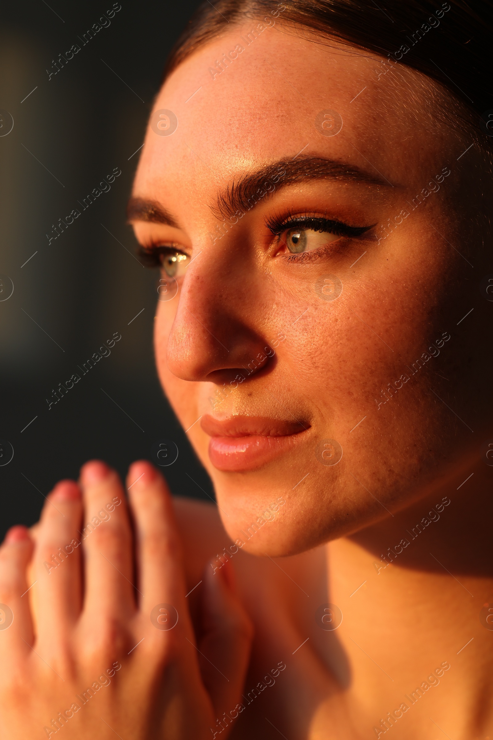 Photo of Fashionable portrait of beautiful woman with fake freckles on dark background, closeup