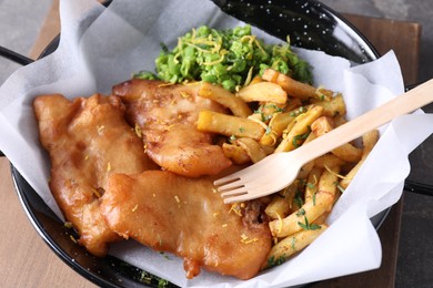 Photo of Tasty fish, chips and peas on table, closeup