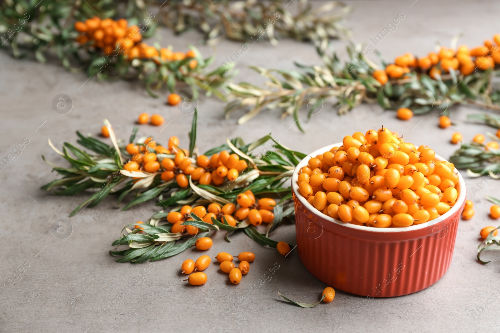 Photo of Fresh ripe sea buckthorn in bowl on grey table