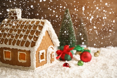 Beautiful gingerbread house decorated with icing and Christmas balls on snow