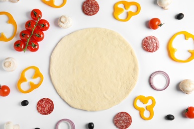 Photo of Flat lay composition with base and ingredients for pizza on white background