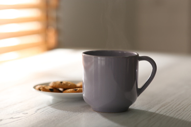 Photo of Tasty coffee and cookies on white wooden table. Good morning