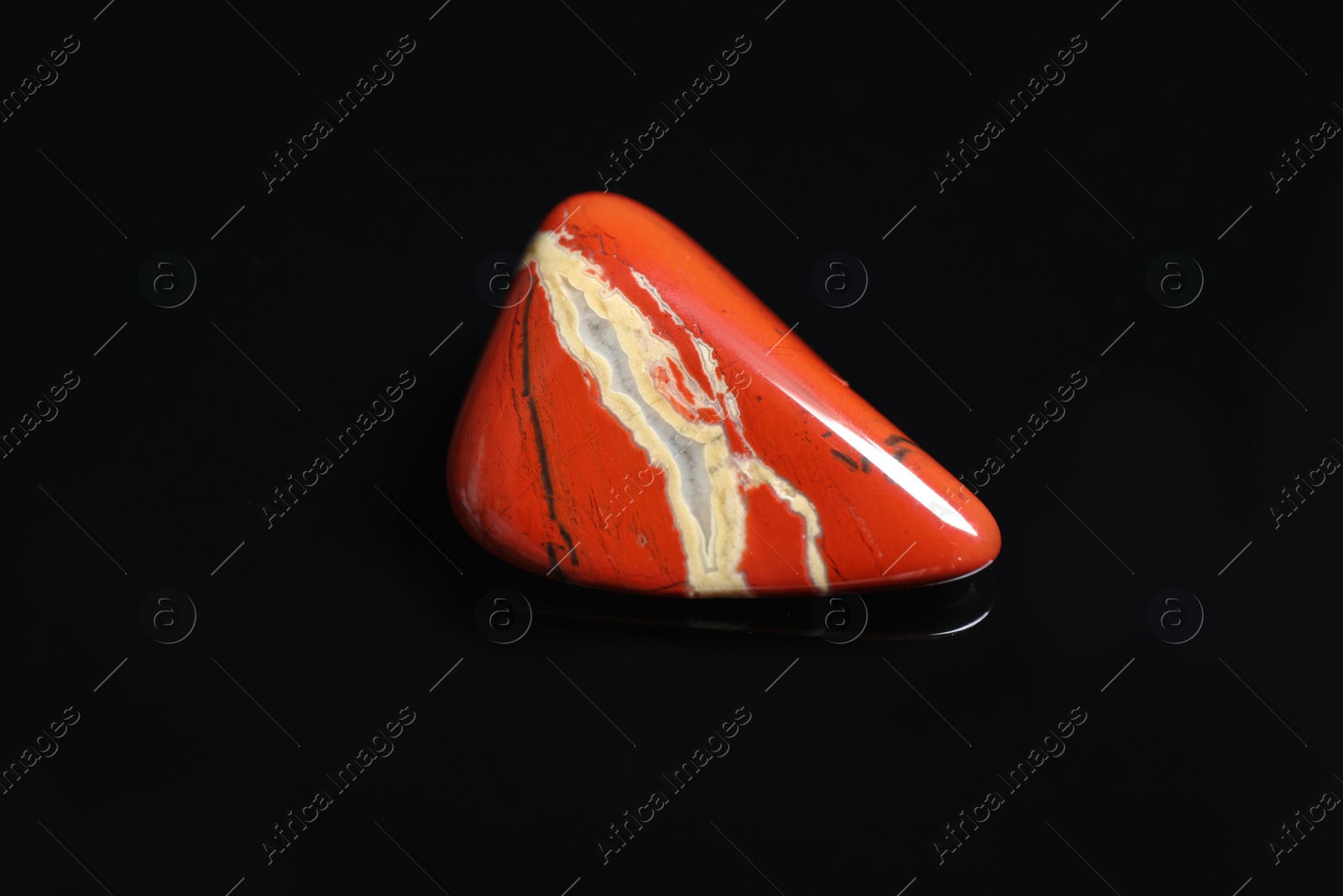 Photo of Beautiful red and white jade gemstone on black background